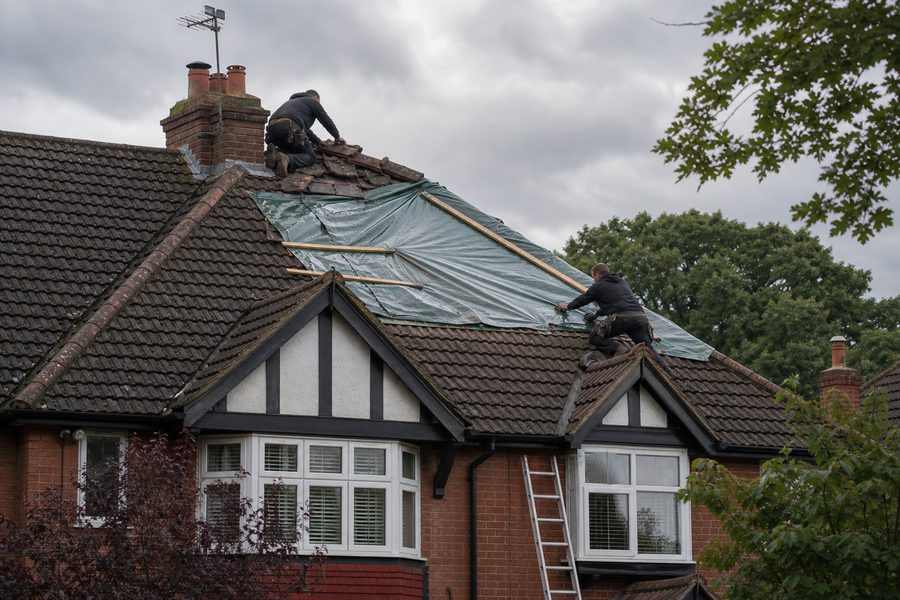 Emergency roofer making safe a storm damaged roof in Chingford